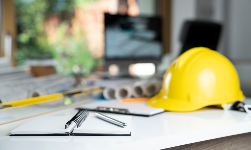 Contractor supplies surrounding a pen and notebook